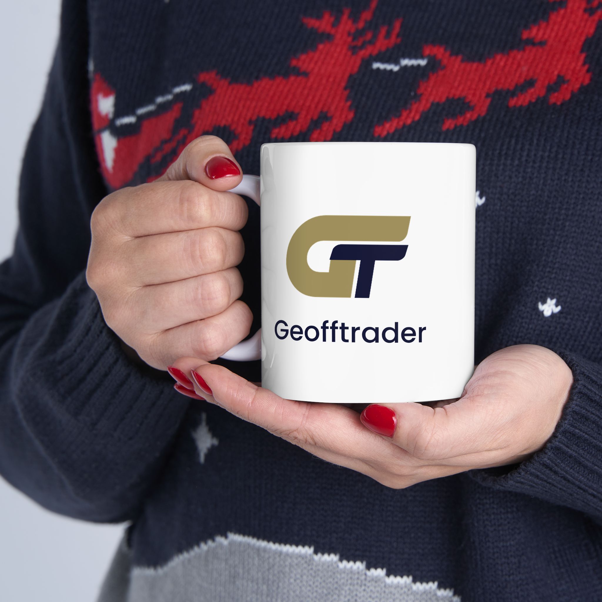 GeoffTrader mug mockup held in two hands, handle on the left