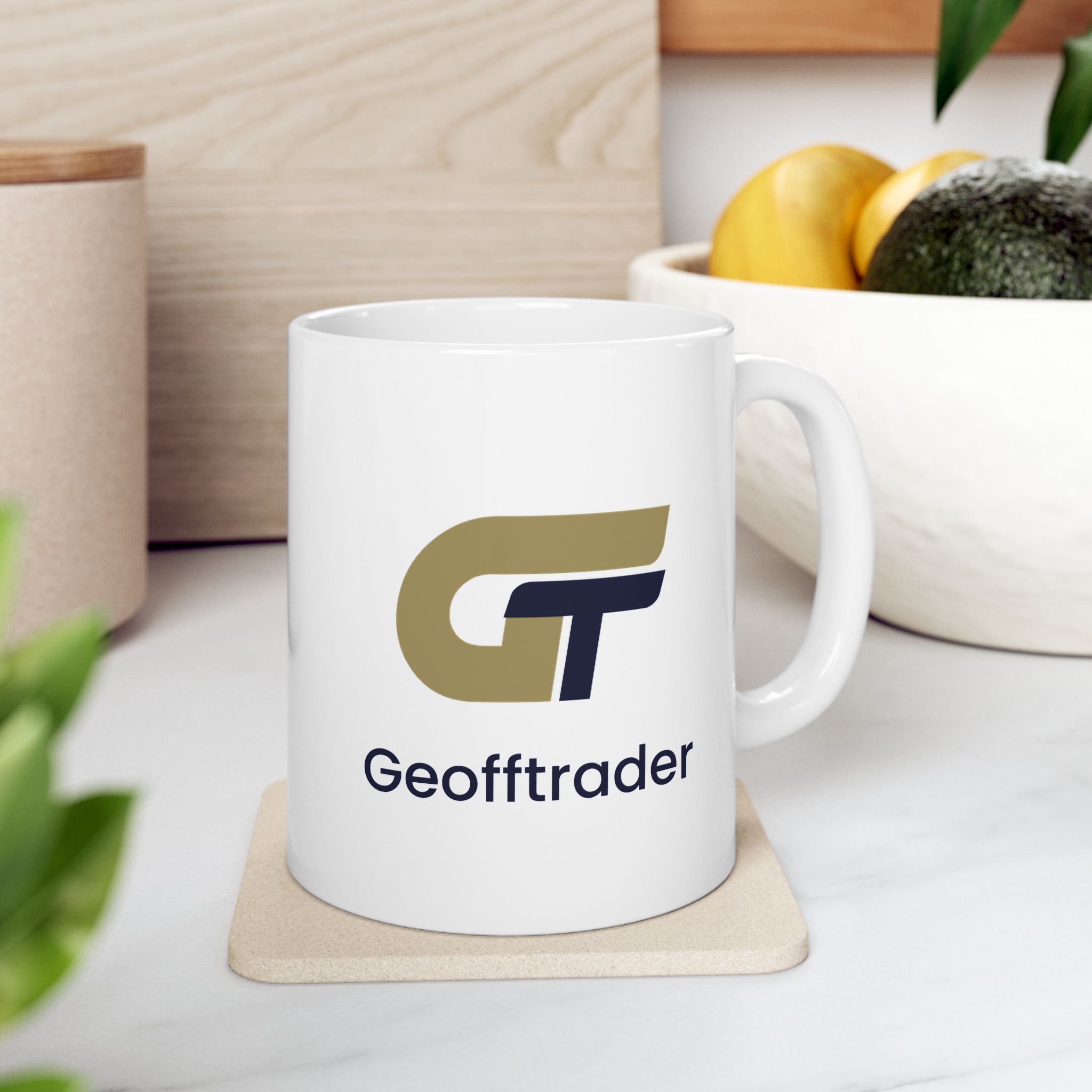 White GeoffTrader mug with gold and navy artwork